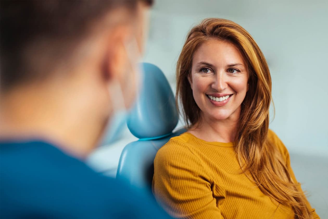 Dr. Maryam Ashraghi answering a smiling patient’s questions at Alpine Dental in Burke, VA