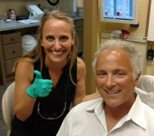 Smiling Alpine Dental provider gives a thumbs up beside a happy patient after his checkup