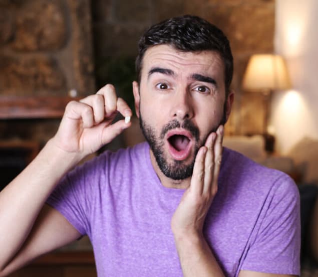 Surprised man touching his jaw and mouth, wondering how to replace missing teeth